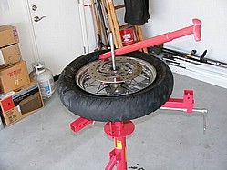 Pulling the first bead off the rim with tire bar
